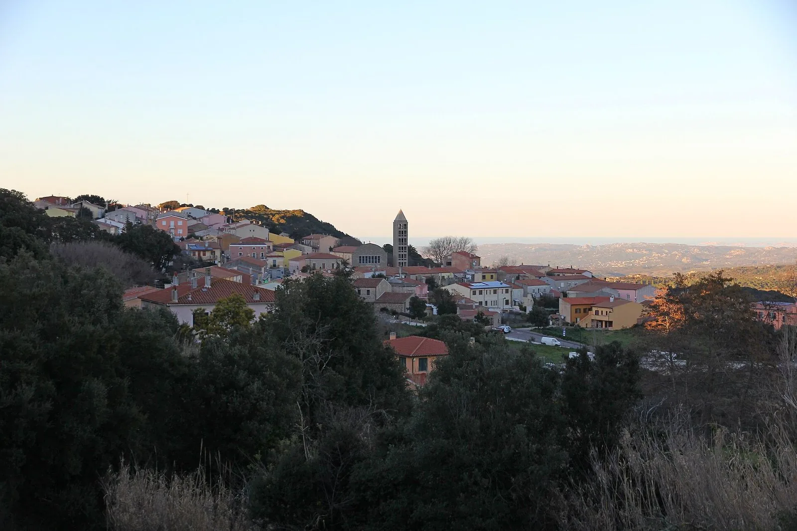 Il paese di Aglientu con il campanile della chiesa di San Francesco e, sullo sfondo, la costa