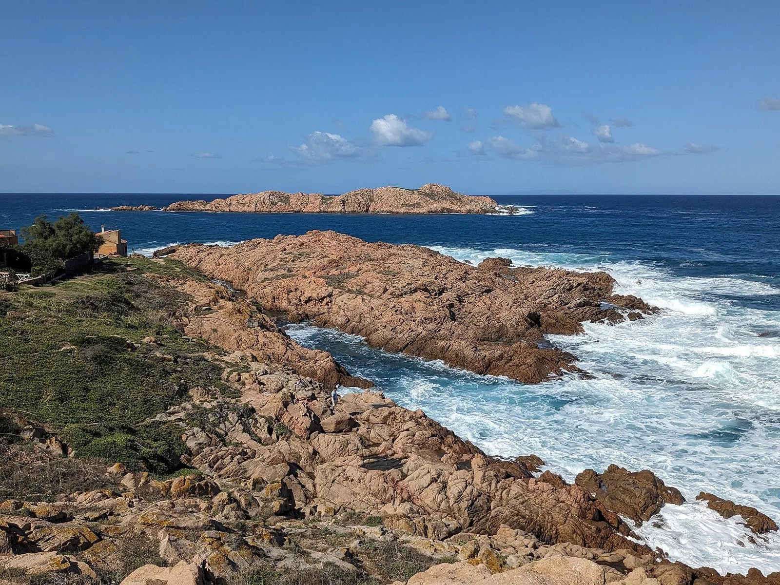Le rocce rosse della costa di Isola Rossa con l'isolotto che dà il nome al borgo