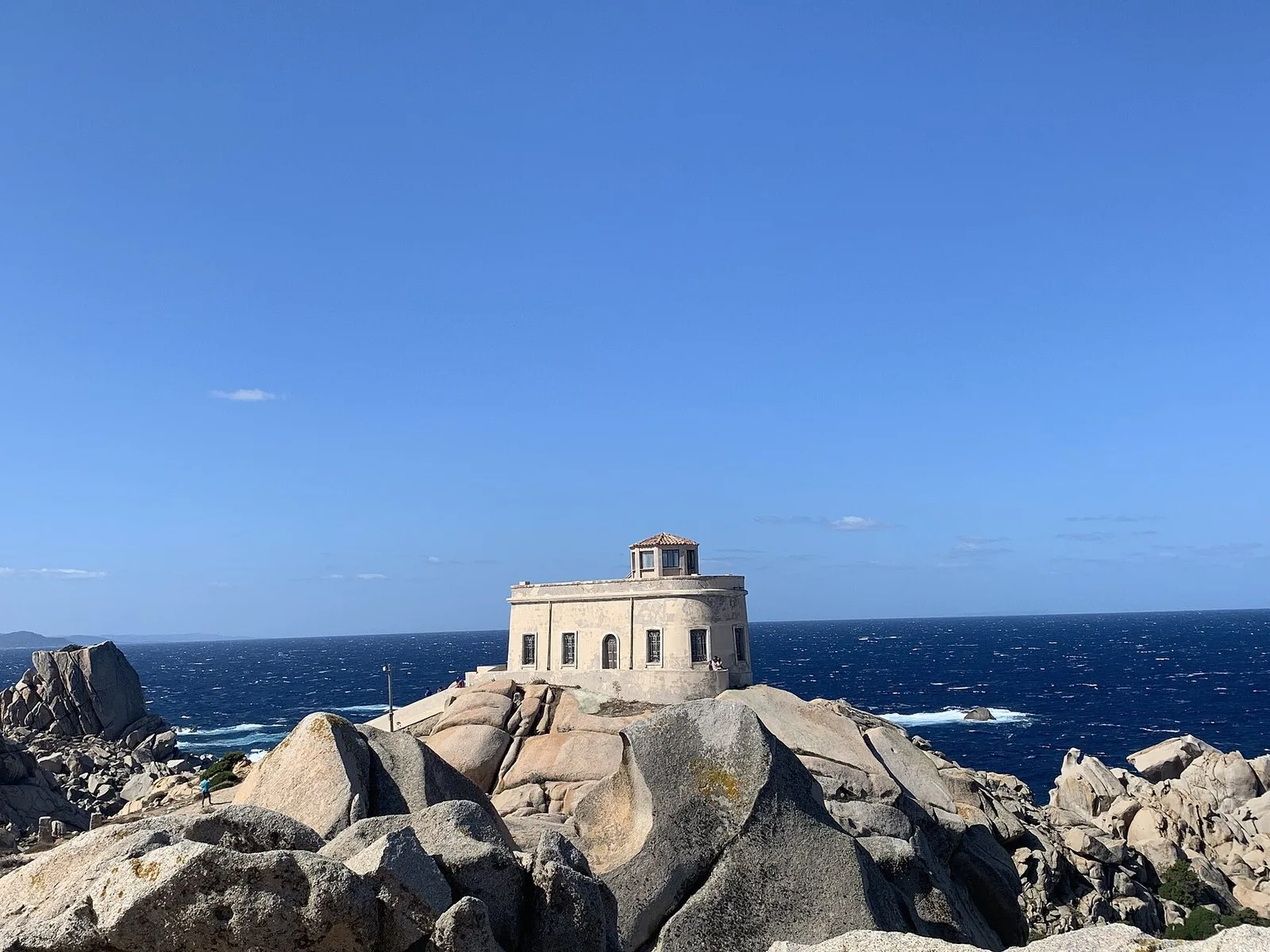 Il faro di Capo Testa sui graniti, con il mare blu mosso dal vento