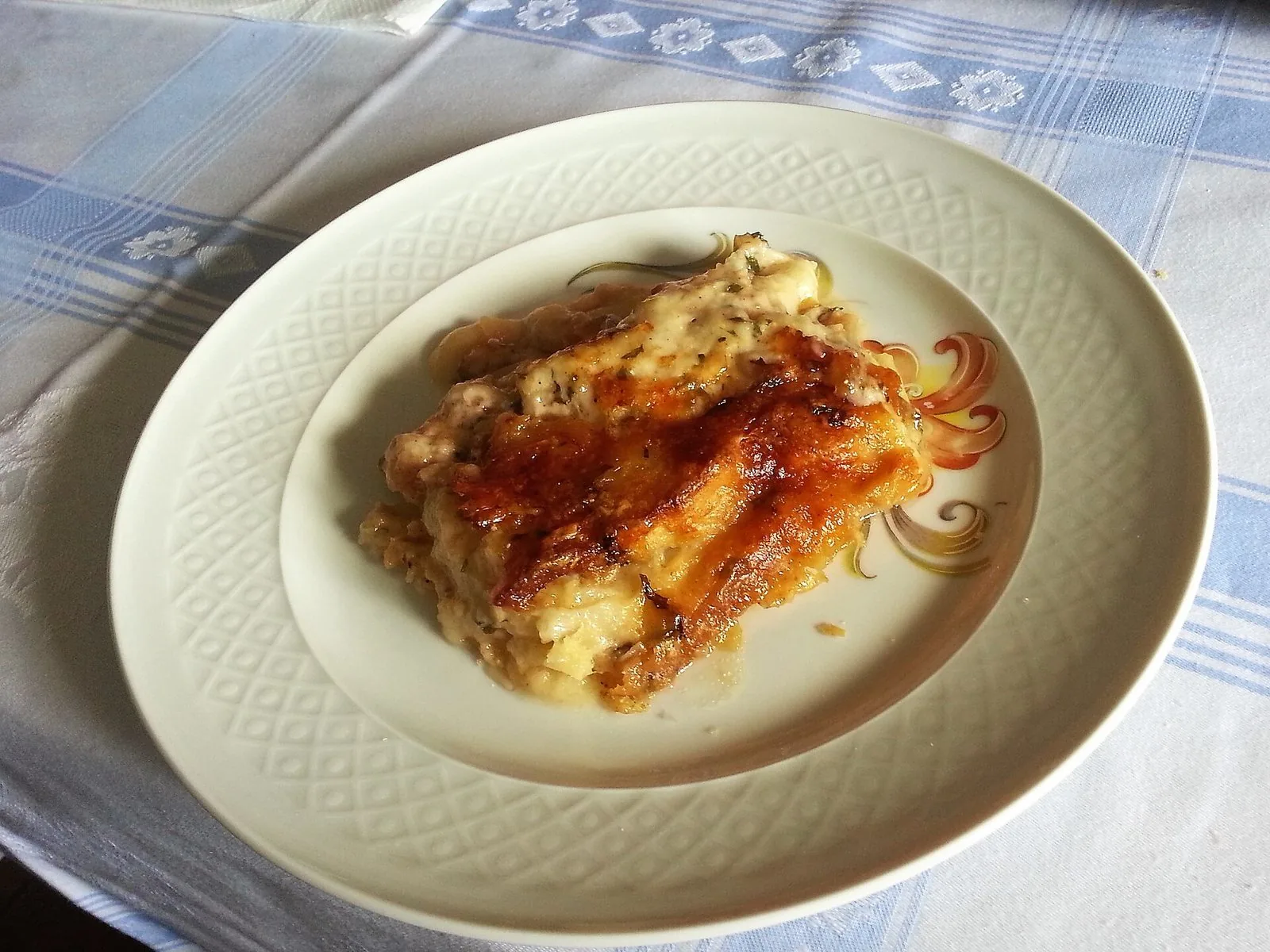 Una porzione di zuppa gallurese gratinata servita nel piatto